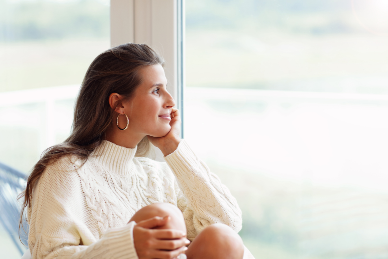 woman removing classes and holding hand to her brow