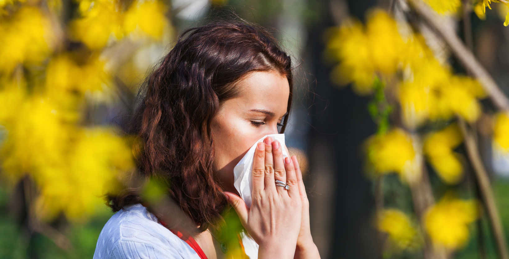 woman removing classes and holding hand to her brow